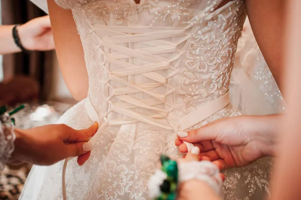 Dama de honra ajudar noiva a usar vestido de noiva — Fotografia de Stock