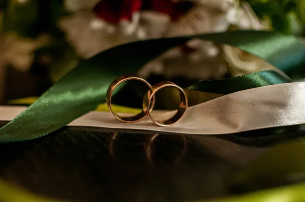 Sepasang cincin emas pernikahan pada pita putih — Stok Foto