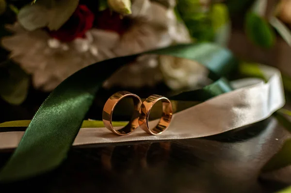 Par de anéis de ouro do casamento na fita branca — Fotografia de Stock
