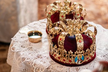 Kilisenin gümüş bardağı ve bir çift altın taçı.