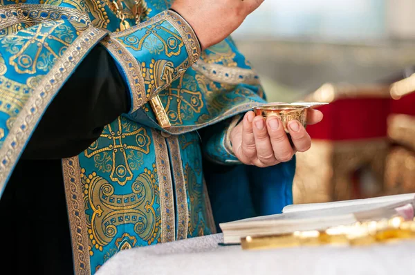 Священник держит серебряную чашу с вином — стоковое фото