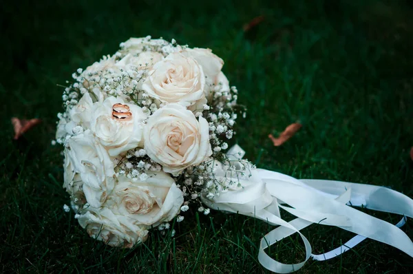 花组成 婚礼花束带丝带 圆环和两个金戒指 — 图库照片