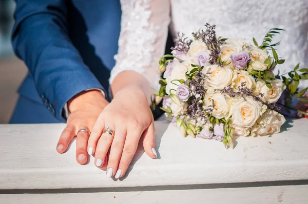 Pair of hands with gold wedding rings on the handrail