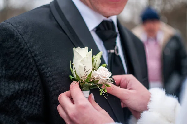 Bride wearing bonbonniere on the grooms jacket