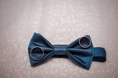 Koyu mavi papyon ve arka planda alyanslar.