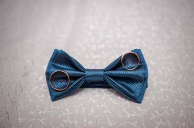 Koyu mavi papyon ve arka planda alyanslar.