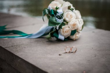 Beyaz bir buket gül ve alyans.