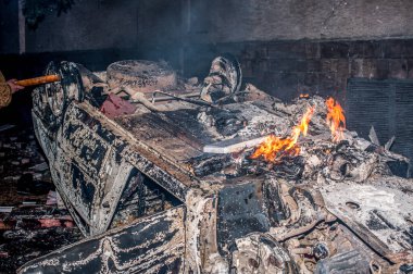 Ternopil, Ukrayna - 18.02.2014 - Yanan polis karakolu yakınında devrilmiş ve yanmış bir araba