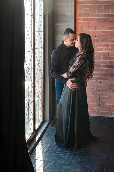 Man and woman in black clothes hugging together — Stock Photo, Image