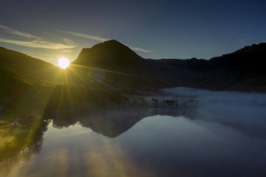 İngiltere 'nin kuzeybatısındaki İngiliz Gölü Bölgesi' ndeki Buttermere gölünün etrafında şafak sisi yükseliyor. Bitişikteki Buttermere köyü adını gölden alır. Tarihsel olarak Cumberland, Cumbria 'da yer alan bir şehirdir. Sahibi kim? 