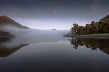 Buttermere 'de şafak vakti, İngiltere' nin kuzeybatısındaki İngiliz Lake District gölünde. Bitişikteki Buttermere köyü ismini gölden alır..