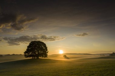 Eshton Yorkshire Dales köyü yakınlarındaki tarım arazisinde güneş doğuyor. Kuzey Yorkshire 'ın Craven ilçesinde küçük bir köy ve sivil bir kilise.