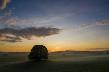 Eshton Yorkshire Dales köyü yakınlarındaki tarım arazisinde güneş doğuyor. Kuzey Yorkshire 'ın Craven ilçesinde küçük bir köy ve sivil bir kilise.