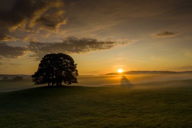 Eshton Yorkshire Dales köyü yakınlarındaki tarım arazisinde güneş doğuyor. Kuzey Yorkshire 'ın Craven ilçesinde küçük bir köy ve sivil bir kilise.