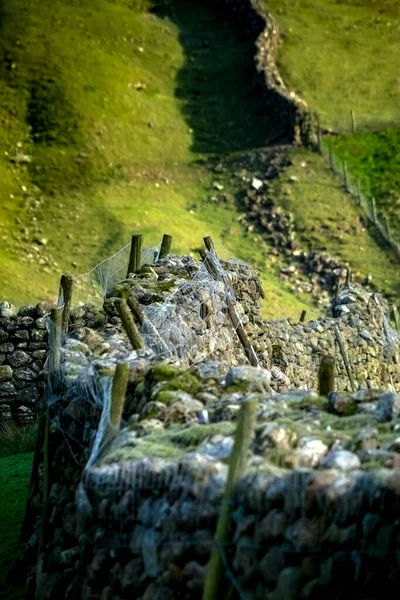 Limestone dry wall in the wasdale valley, with wire fencing to stop sheep jumping over