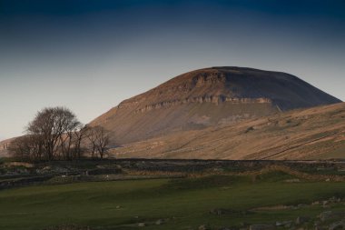Penyghent 'in dramatik alçak açısı sonbahar günbatımına kadar aydınlanır.