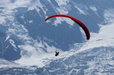 Paragliderler Monte Blanc Massif, Chamonix, Fransa 'nın kar kütleleri arasında ısı dalgaları arıyorlar.