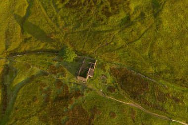 Top Withens ya da Top Withins 'in hava gündoğumu drone çekimi, bu çiftlik evi 