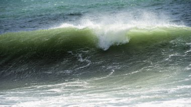 Dalgalar İngiltere 'nin Cornish sahillerindeki kayalıklara ve plajlara çarpar.