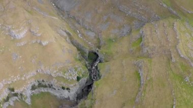 İnsansız hava aracı görüntüleri Gordale Scar, Malham, Kuzey Yorkshire, İngiltere 'nin 1,5 km kuzeydoğusundaki bir kireçtaşı vadisidir. İki şelale içeriyor ve 100 metre yüksekliğinde kireçtaşı kayalıkları var.