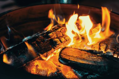 Sarı ve turuncu alevlerle orta büyüklükte parlak şenlik ateşi