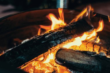 Sarı ve turuncu alevlerle orta büyüklükte parlak şenlik ateşi