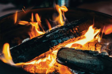 Sarı ve turuncu alevlerle orta büyüklükte parlak şenlik ateşi