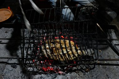 Kömürden ızgara balık yapma ve takımadalardan lezzetli ızgara balıklar üretmek için geleneksel Java baharatlarıyla özel java yemekleri yapma süreci.