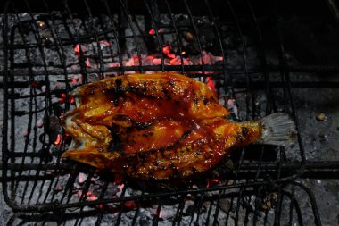 Kömürden ızgara balık yapma ve takımadalardan lezzetli ızgara balıklar üretmek için geleneksel Java baharatlarıyla özel java yemekleri yapma süreci.