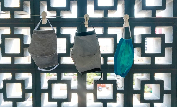 Ev yapımı bir ipe asılmış koruyucu yüz maskeleri. 