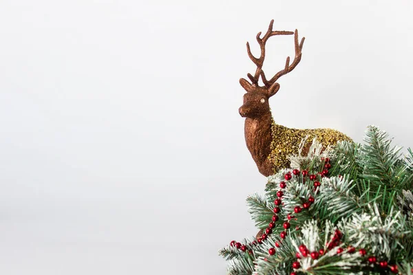 Коричневый золотой олень с вечнозеленым декором с красным шаром — стоковое фото