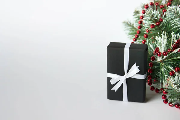 Regalo de Navidad en papel negro y con lazo de cinta de satén blanco ne —  Fotos de Stock