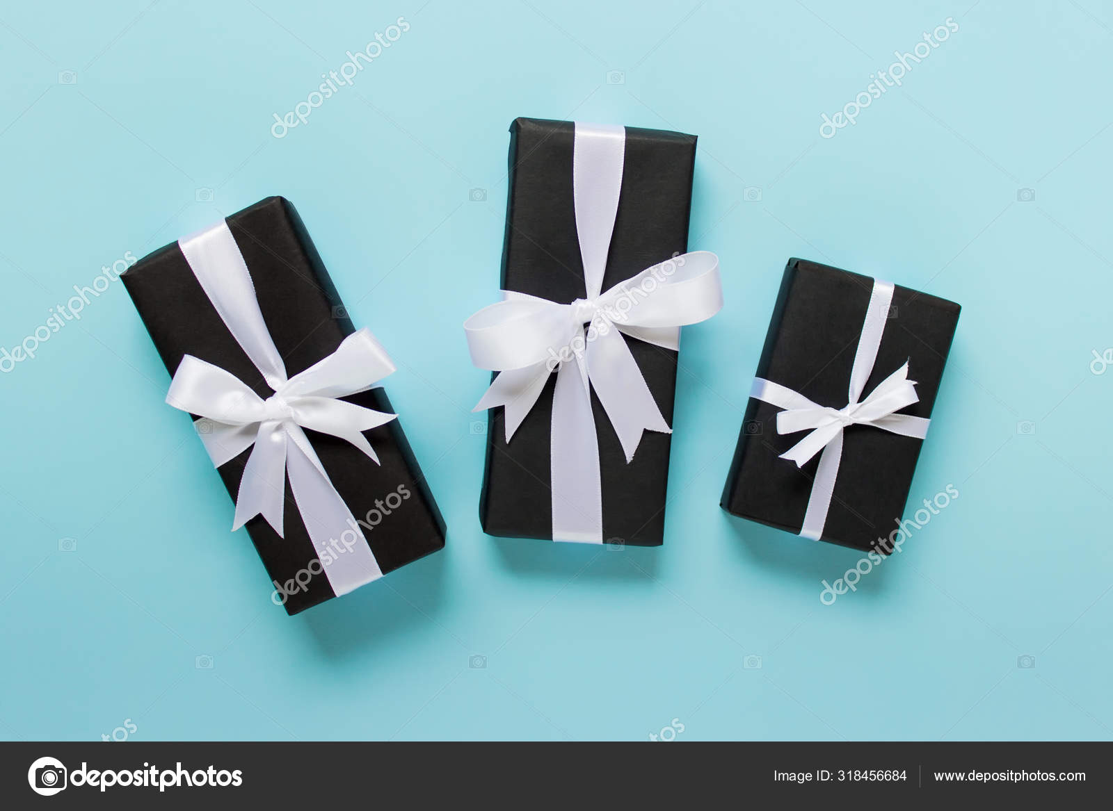 Three gifts presents in black wrapping paper with white bows Stock Photo by  ©DariaRen 318456684