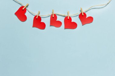 Yük ipliğine tutturulmuş kırmızı kumaşlı kalpler.