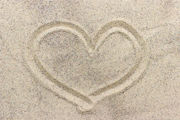 Forma del corazón dibujada sobre la superficie de arena — Foto de Stock