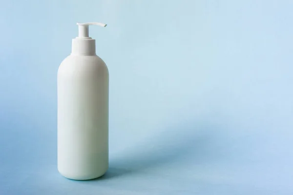 用蓝色底色的白色塑料香皂瓶调味 带有复制空白的照片 — 图库照片