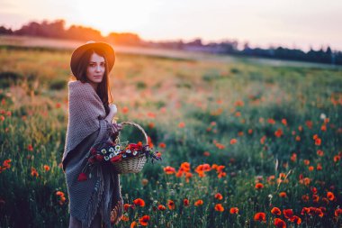 Gün batımında tarlada poz veren güzel bir kadın..