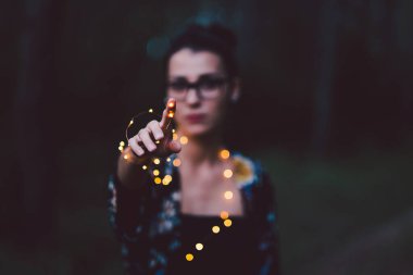 Siyah tişörtlü, siyah arka planda silahlı genç bir adam.