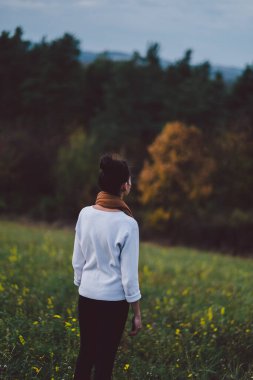 Genç kız sonbaharın başlarında dışarıda dinleniyor. 