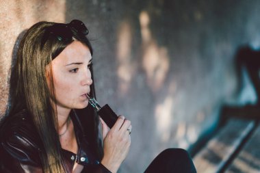 Genç bir kadın kafede sigara içiyor.