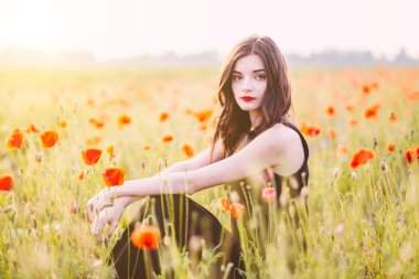 Gün batımında tarlada poz veren güzel bir kadın..