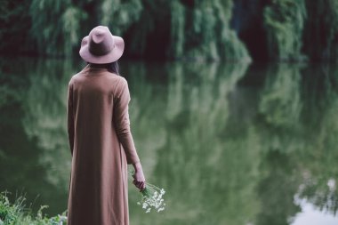 Genç kız gölün kenarında dinleniyor.