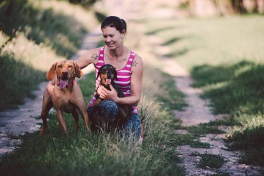 Çimlerin üzerinde köpeği olan güzel genç bir çift.