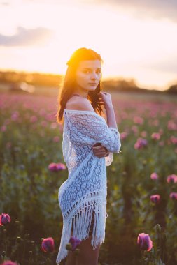 Gün batımında tarlada poz veren güzel bir kadın..