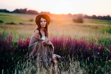 Gün batımında tarlada poz veren güzel bir kadın..