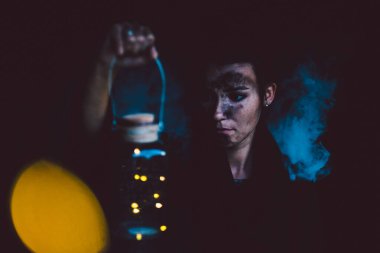 Duman içinde dövmeli genç bir adam.