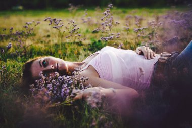 Çiçekli bir tarlada güzel bir genç kadın.