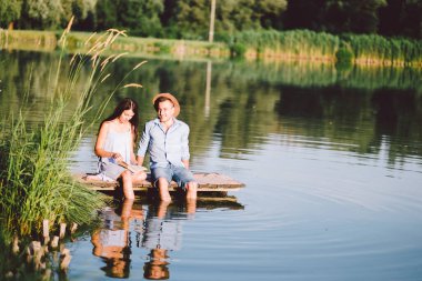 Genç bir aile yaz günü bir gölde oturuyor.