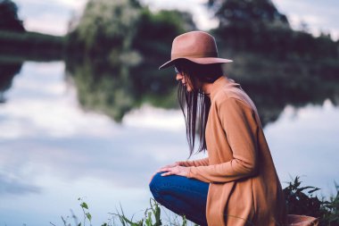 Genç kız gölün kenarında dinleniyor.