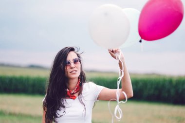 Sahada balonları olan mutlu genç bir kadın.